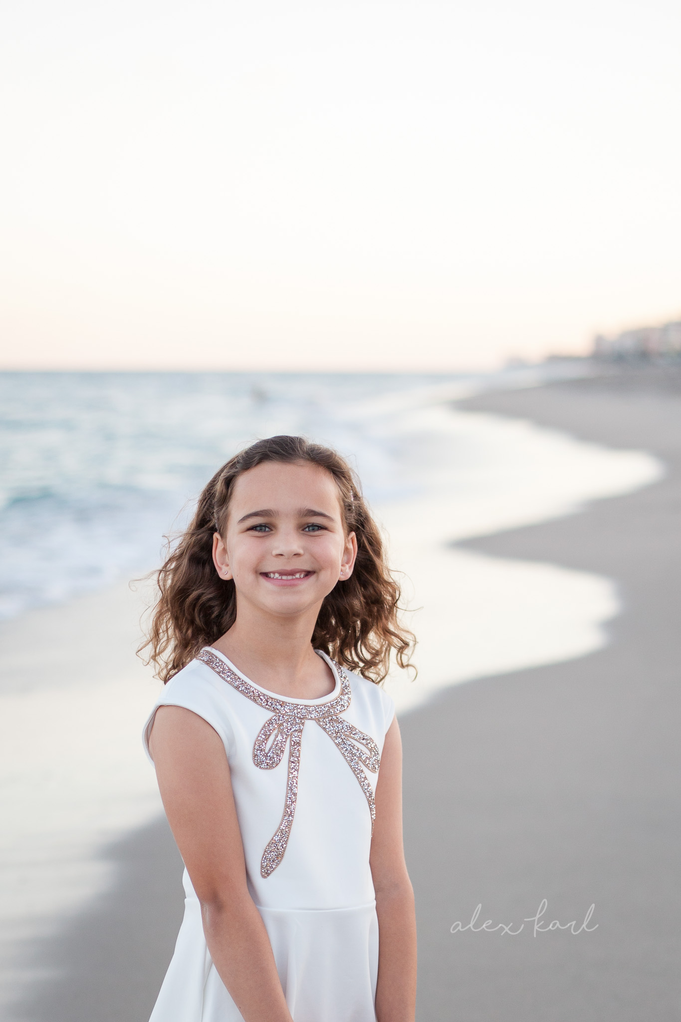 A girl smiles in front of the ocean | Alex Karl Photography | Palm Beach Family Photographer